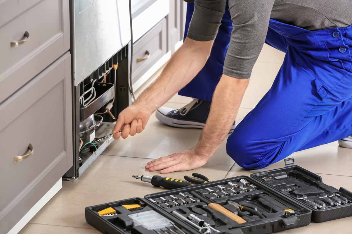 Technician repairing a refrigerator
